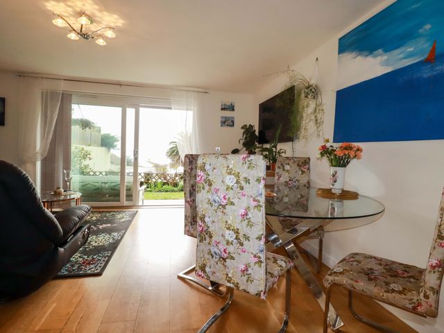 A living room with a glass dining table and sliding doors at 2 Morweth View in Torpoint