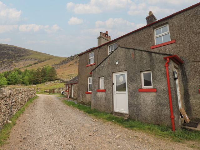 A house exterior near a dirt path at Easthwaite Cottage in Nether Wasdale near Wastwater