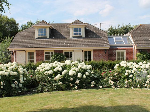 A house with flowers in the garden at New Barn in Broad Chalke