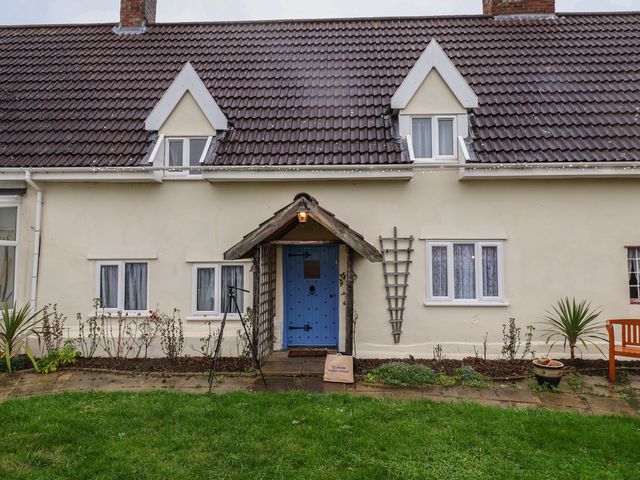 A house with a blue door and windows at Driftway Cottage in Diss