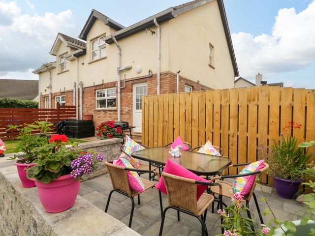 A garden with a table and chairs surrounded by flowers at Primrose Seaside Escape in Portrush, County Antrim