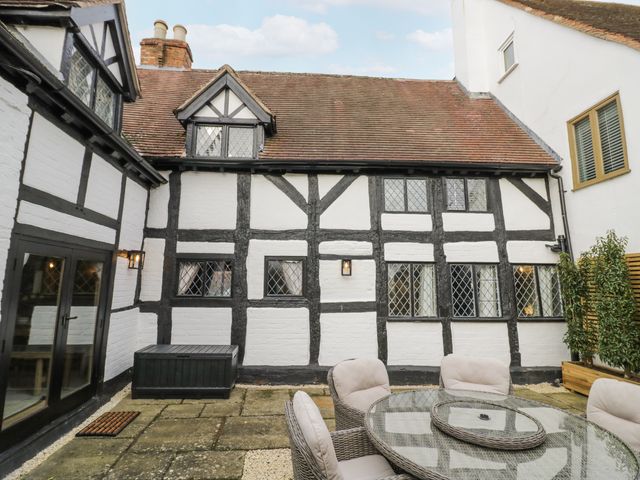 An outdoor seating area with a table and chairs at Weston Cottage Stratford-upon-Avon