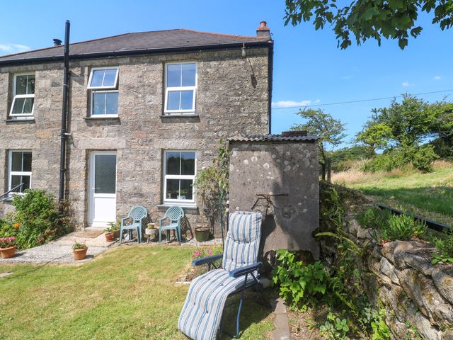 A garden with lawn chairs and plants at Halwyn Farm in Helston