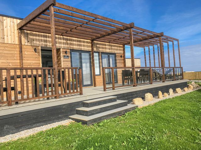 An outdoor deck with seating and steps at Pentewan in Redruth