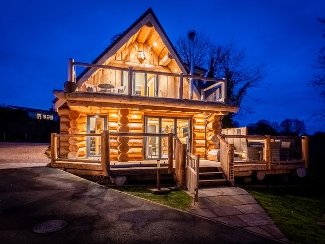 A log cabin with a deck and lighting at Keepers Cabin Addingham