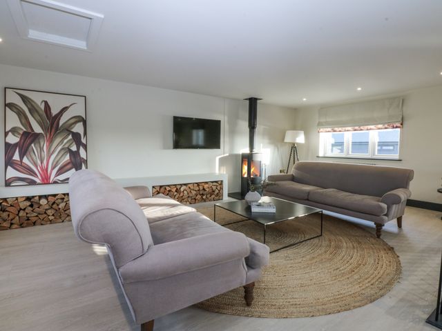 A living room with sofas and a fireplace at Bell House in Llanfechell