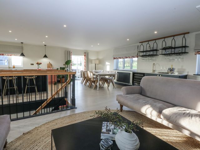 A living room with a sofa and dining area at Bell House in Llanfechell