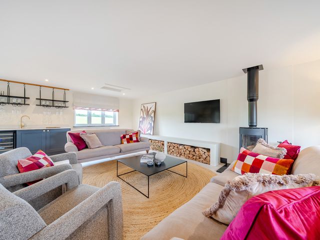 A living room with a sofa and armchairs at Bell House in Llanfechell
