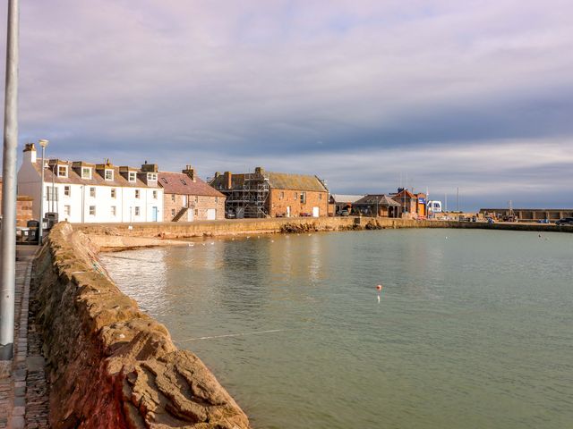 A harbor with buildings along the water at The Harbour Hoose Stonehaven