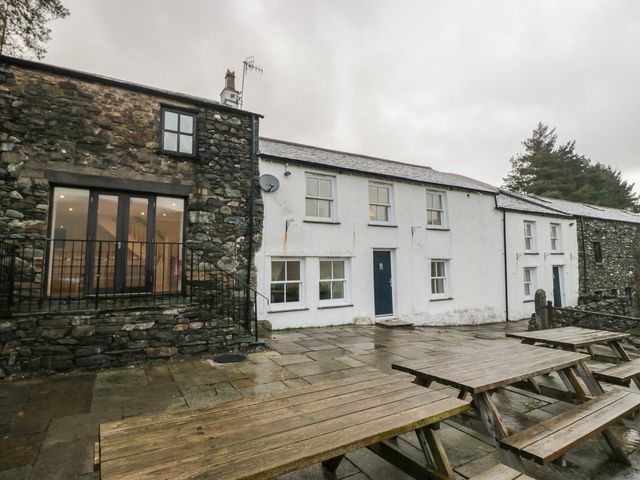 An exterior view of a stone building with patio seating at Newlands Fell House near Keswick
