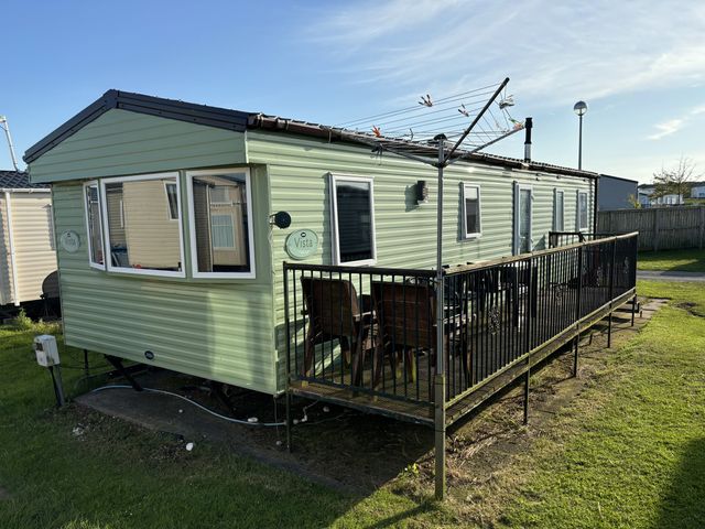 A mobile home with a deck and furniture at Gannet 16 (G16) Bridge Of Allan