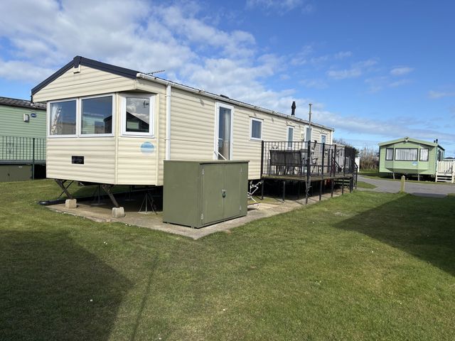 A mobile home with green storage unit on a deck in Jay valley 35 (J35) Lichfield