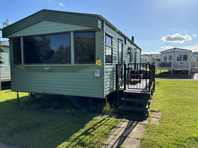 A green caravan with a staircase and outdoor area at Dunlin dell 45 (D45) Bridlington