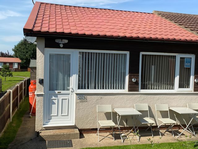 An outdoor area with seating and a door at Chalet in Bridlington