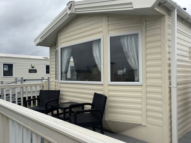 A caravan with a deck and chairs at Skegness Holiday Park Skegness