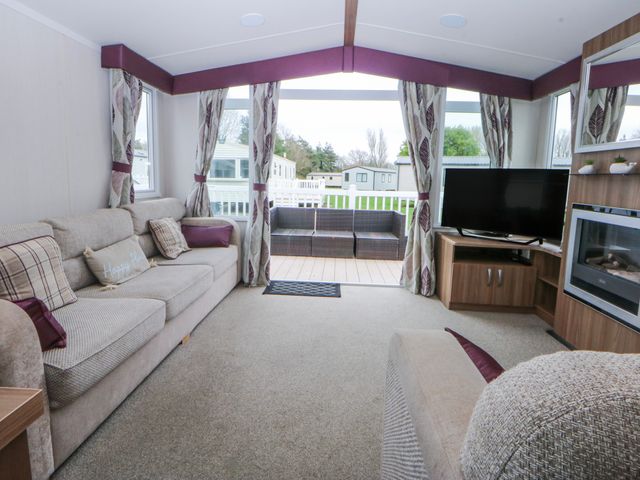 A living room with a sofa and television at 49 Cader Idris Hafan-Y-Mor Holiday Park Pwllheli