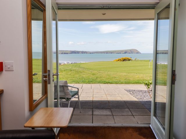 A living room with a view of the sea and a chair at Ty Mor in Newport, Pembrokeshire