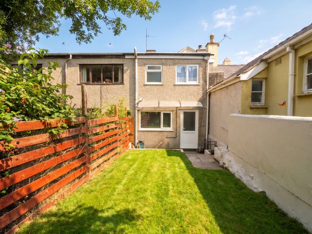 A garden with grass and a fence at Emily Rose Cottage Bangor