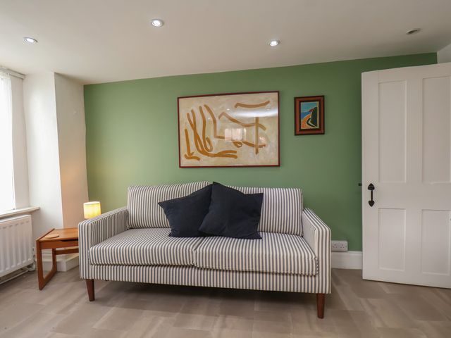 A living room with a sofa, painting and table at Apartment at Mulgrave House Hinderwell near Staithes
