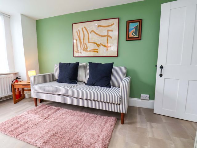 A living room with a striped sofa and art on the wall at Apartment at Mulgrave House in Hinderwell near Staithes