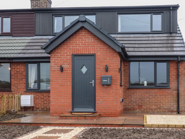 An exterior view of a house with a brick wall and front door at Wardenlea Preston