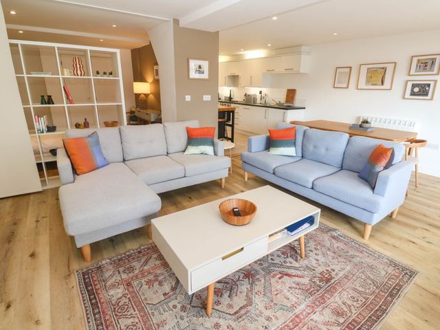 A living room with a sofa and coffee table at 11 Fountain Court in Falmouth