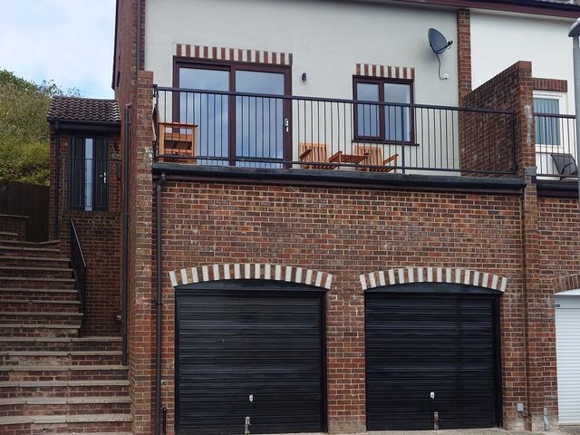 A house with a balcony and garages at Upper Longlands Dawlish