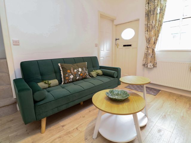 A sitting room with a green sofa and two coffee tables at 14 Crown terrace Belper