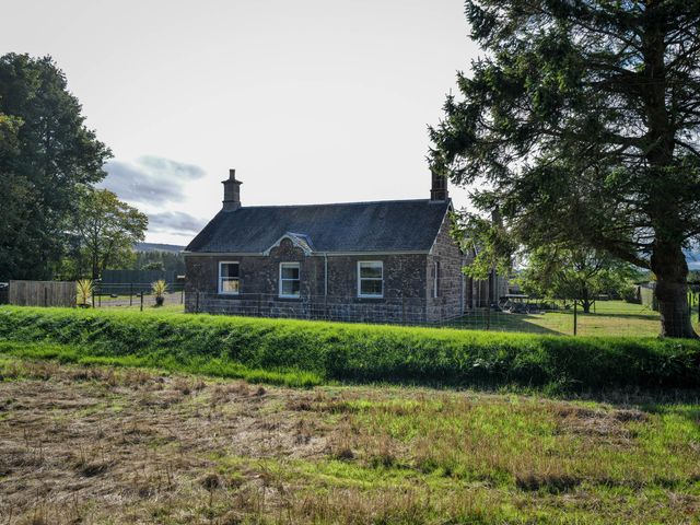 A cottage surrounded by grass and trees at East Camno Farm Cottage Meigle