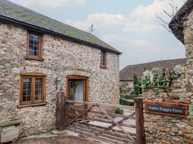 An exterior view of Higher Ruggin Farm in Wellington with stone walls and a wooden gate