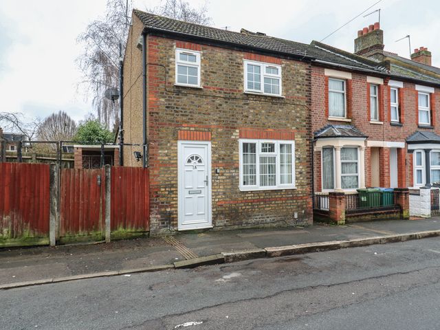 A house with a front door and windows on the street at Headmasters Hollow Watford