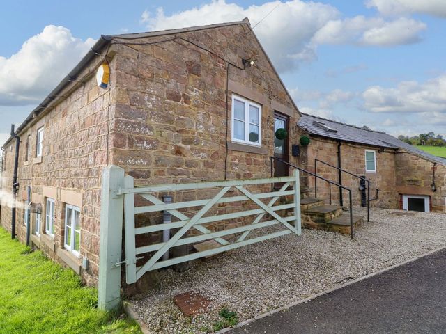 An outdoor view of a stone house with a gate and steps at The Annexe in Belper
