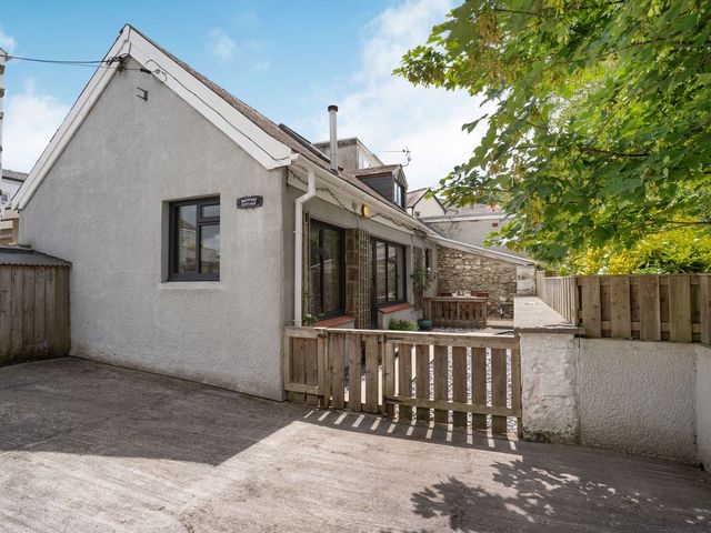 A house with a deck and tree at Brewery Cottage