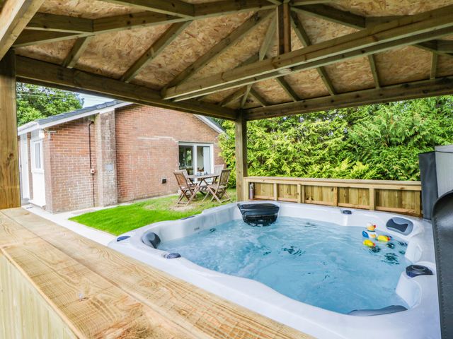 An outdoor area with a hot tub and seating at The Croft in Llandrindod Wells