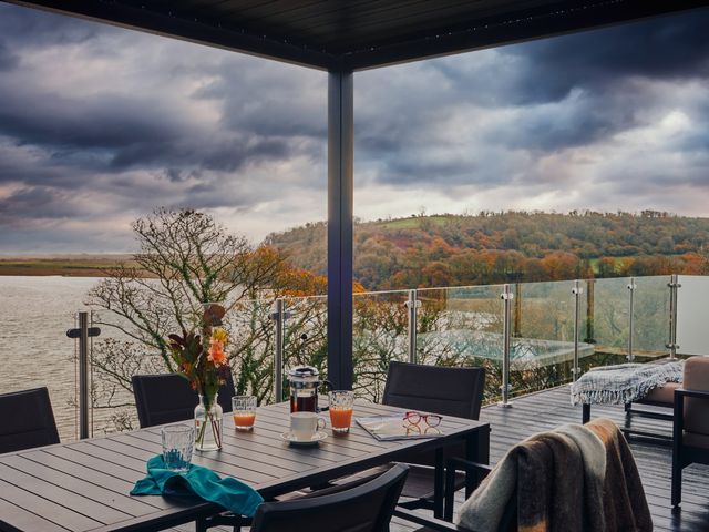 An outdoor seating area with a table and chairs overlooking the landscape at Wilde Spa in Carmarthen