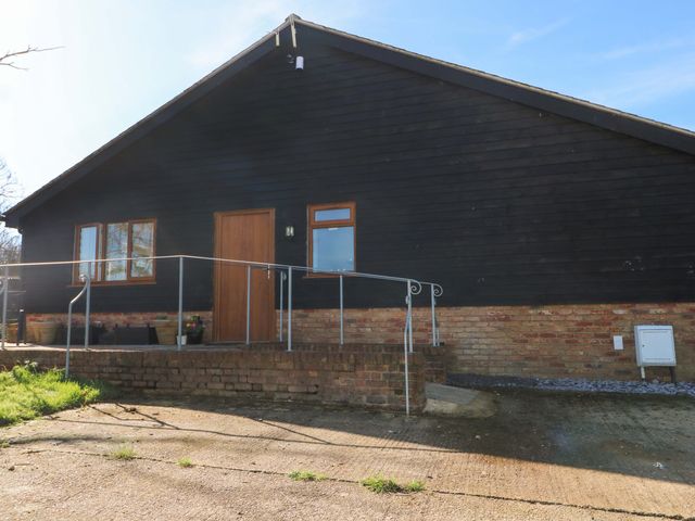 An exterior view of a house with steps and a handrail at Blue Bell Cottage near Lenham