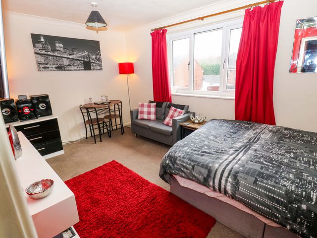A bedroom with a bed, sofa and dining table at Cosy Nook Leeds