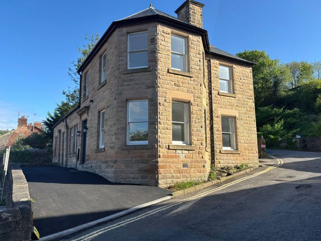 A house with multiple windows and a parking area at Holt Hall - First Floor Apartment Matlock