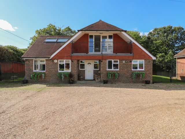 An exterior view of a house with a gravel driveway at Panel Place near Pett
