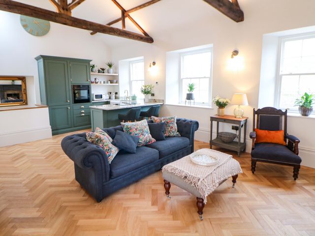 A living room with a sofa and kitchen area at The Reading Room Hope Valley