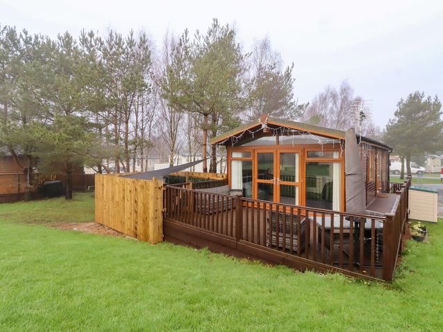An outdoor view of a cabin with a deck at Harper's Hideaway near Felmoor Holiday Park near Felton