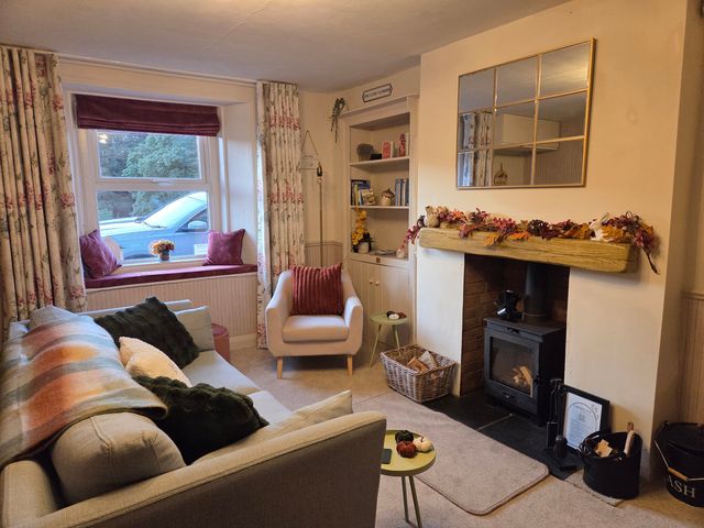 A living room with a sofa and armchair at Willow Wood in Langcliffe near Settle