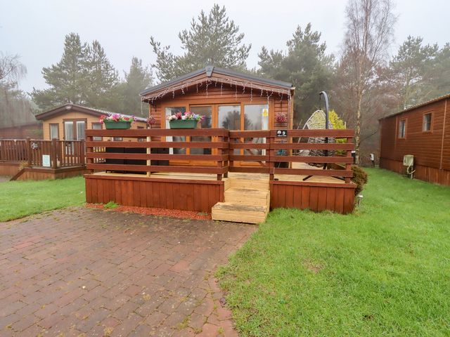 A log cabin with wooden deck and steps at Chloe's Cabin near Felmoor Holiday Park near Felton