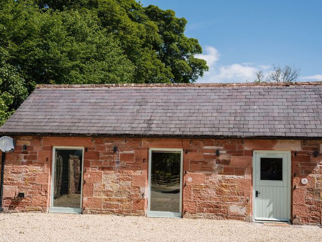 An outdoor view of a stone building with windows and doors at Carwinley Mill House Cottage in Carwinley near Longtown