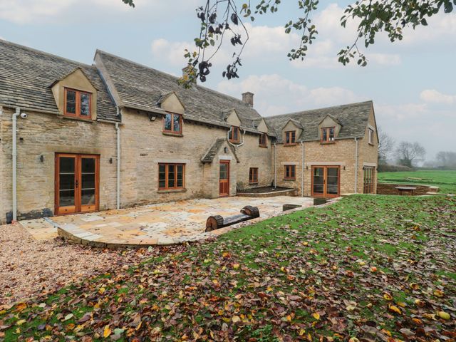A house with windows and patio area at Manor Cottage Carterton, Oxfordshire