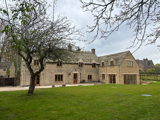 A house with windows and a tree in the outdoor area at Manor Cottage in Bampton, Oxfordshire