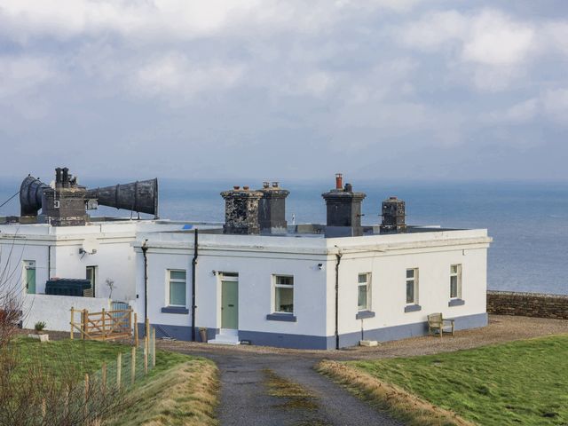 An outdoor view of a building with a path and grass at Hornblower Lodge in Whitby