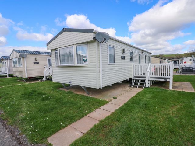 A caravan exterior with a satellite dish and steps at 82 Manorbier Park in Manorbier