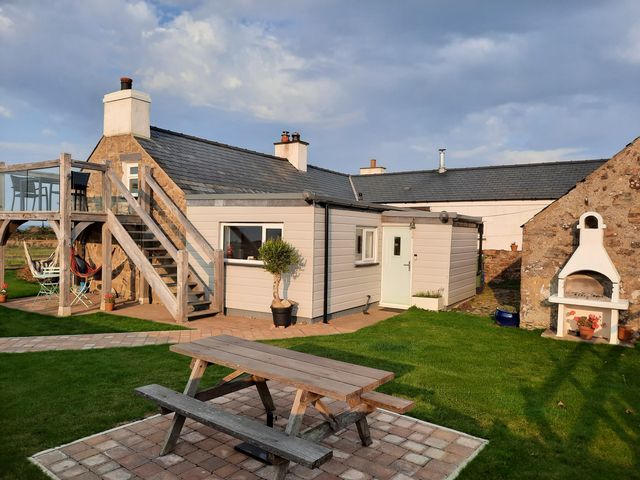 An outdoor area with a house, stairs, and seating at Parc y Brenin Holidays, Abersoch