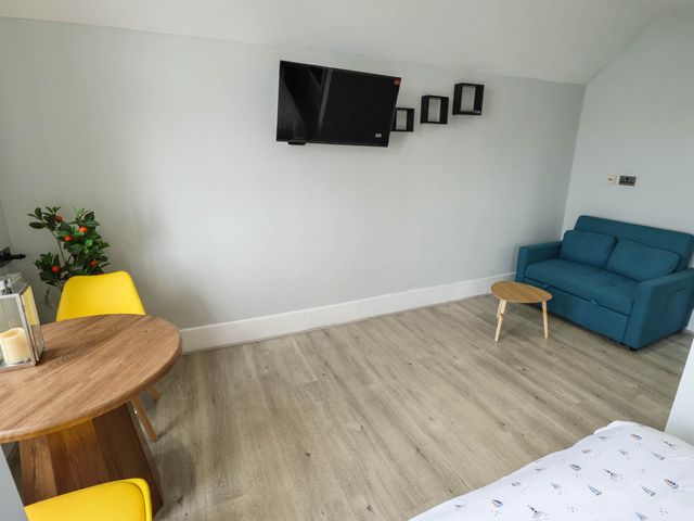 A living room with a sofa, table, and tv at The Ocean House --- Sea Whisper (Top Floor ) Le Strange Terrace, Hunstanton